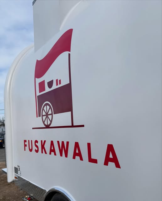 Close-up of the FuskaWala cart logo, a red Bangladeshi street food cart with flag